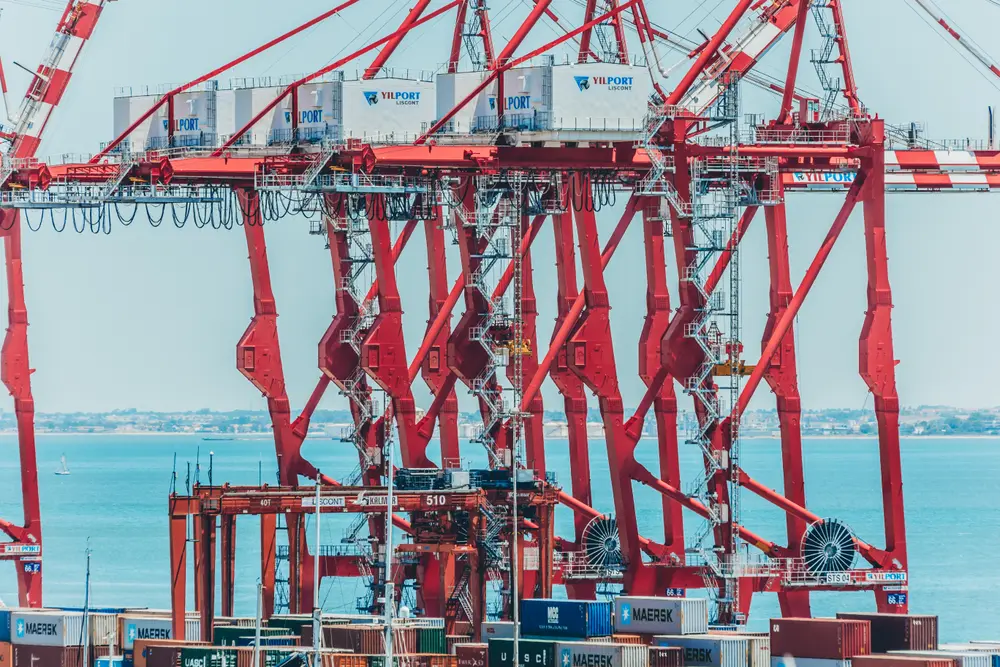 Gruas-pórtico vermelhas do porto de Lisboa, recortadas sobre o rio