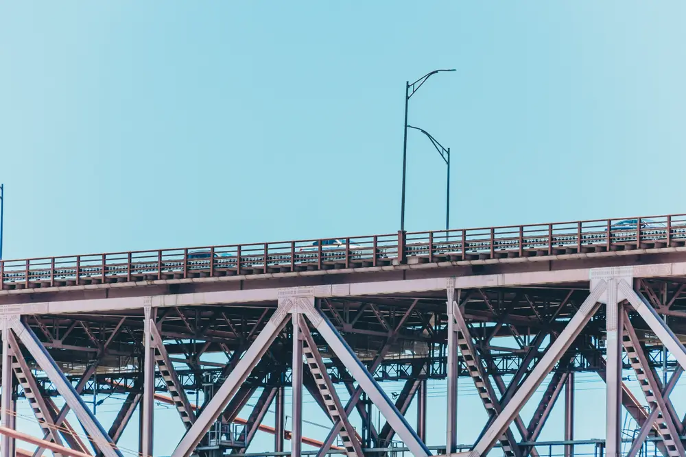 Estrutura metálica da ponte 25 de Abril, com um poste de iluminação