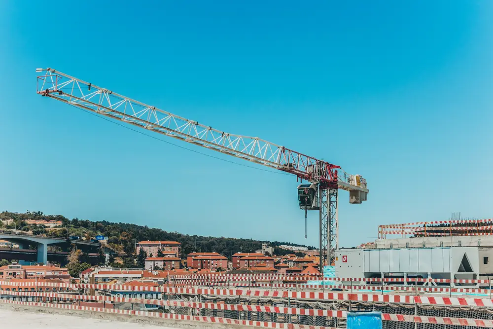 Grua-torre sobre o estaleiro, com a cidade e a ponte ao fundo