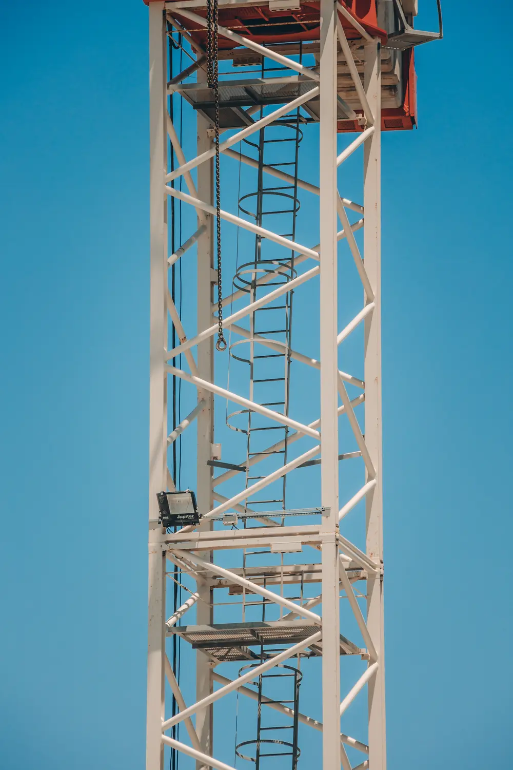 Mastro da grua visto de frente, contra o céu azul