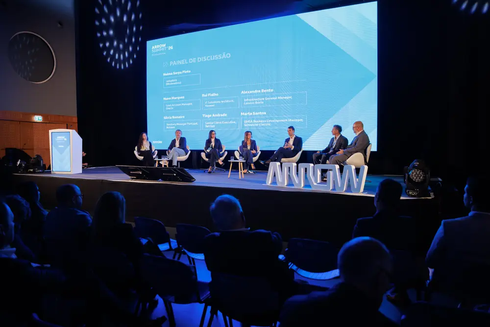 Painel de debate em palco, visto do fundo da sala