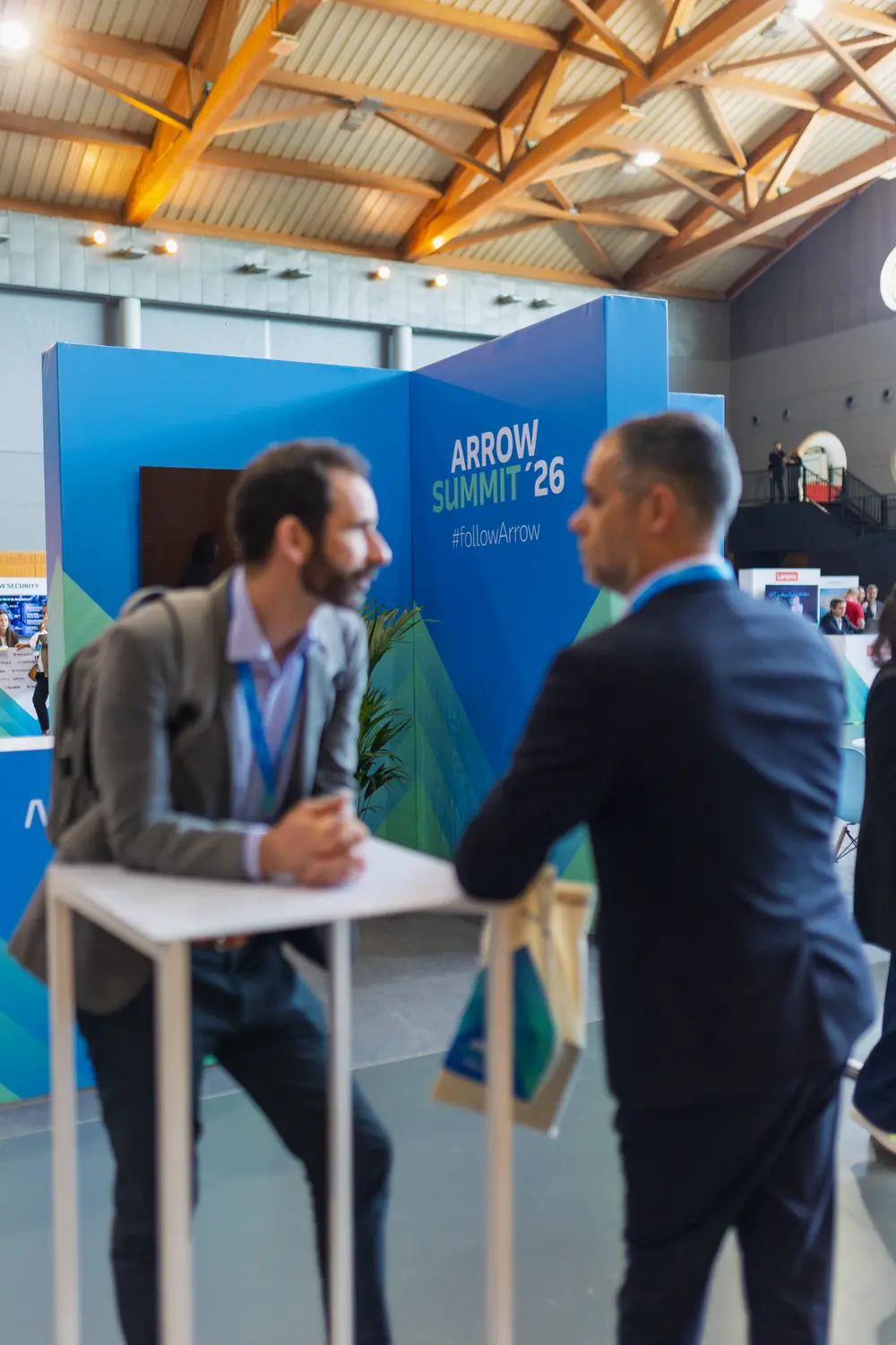 Dois convidados em conversa junto ao painel do summit