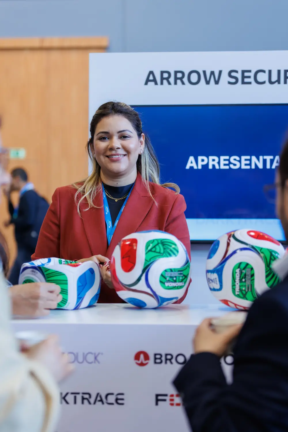 Representante no stand da Arrow Summit, com bolas de futebol como brinde
