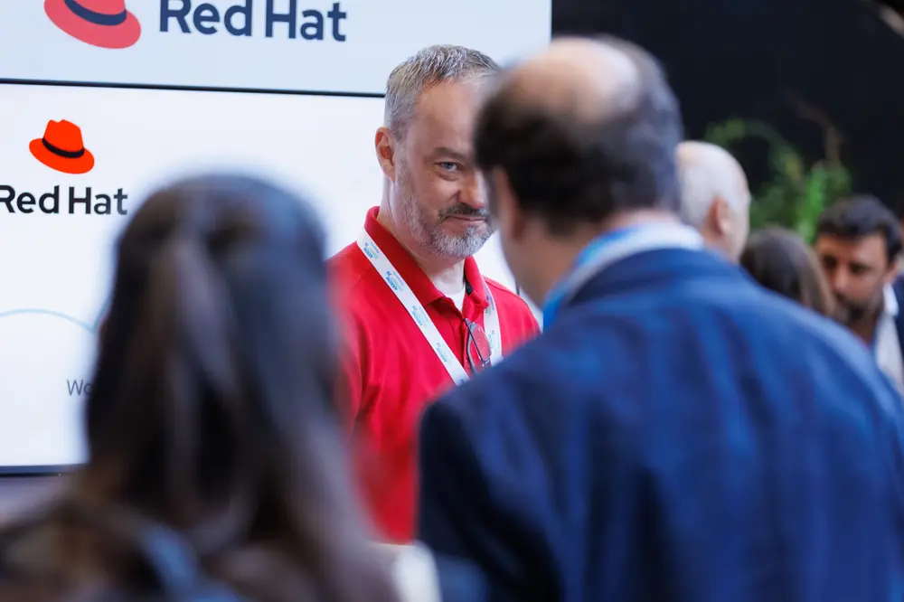 Conversa com convidados junto ao stand da Red Hat