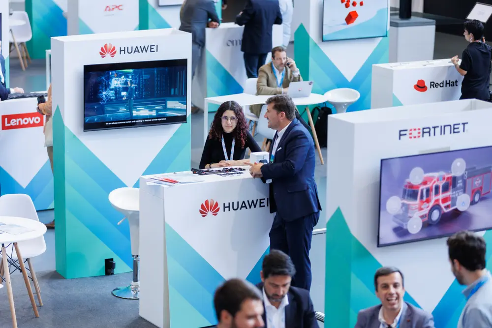 Stands da Huawei e da Fortinet, com participantes a circular