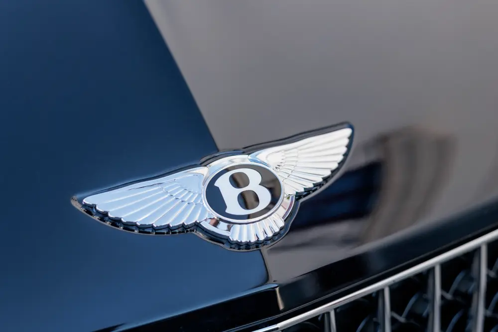 Emblema alado da Bentley no capô, em grande plano