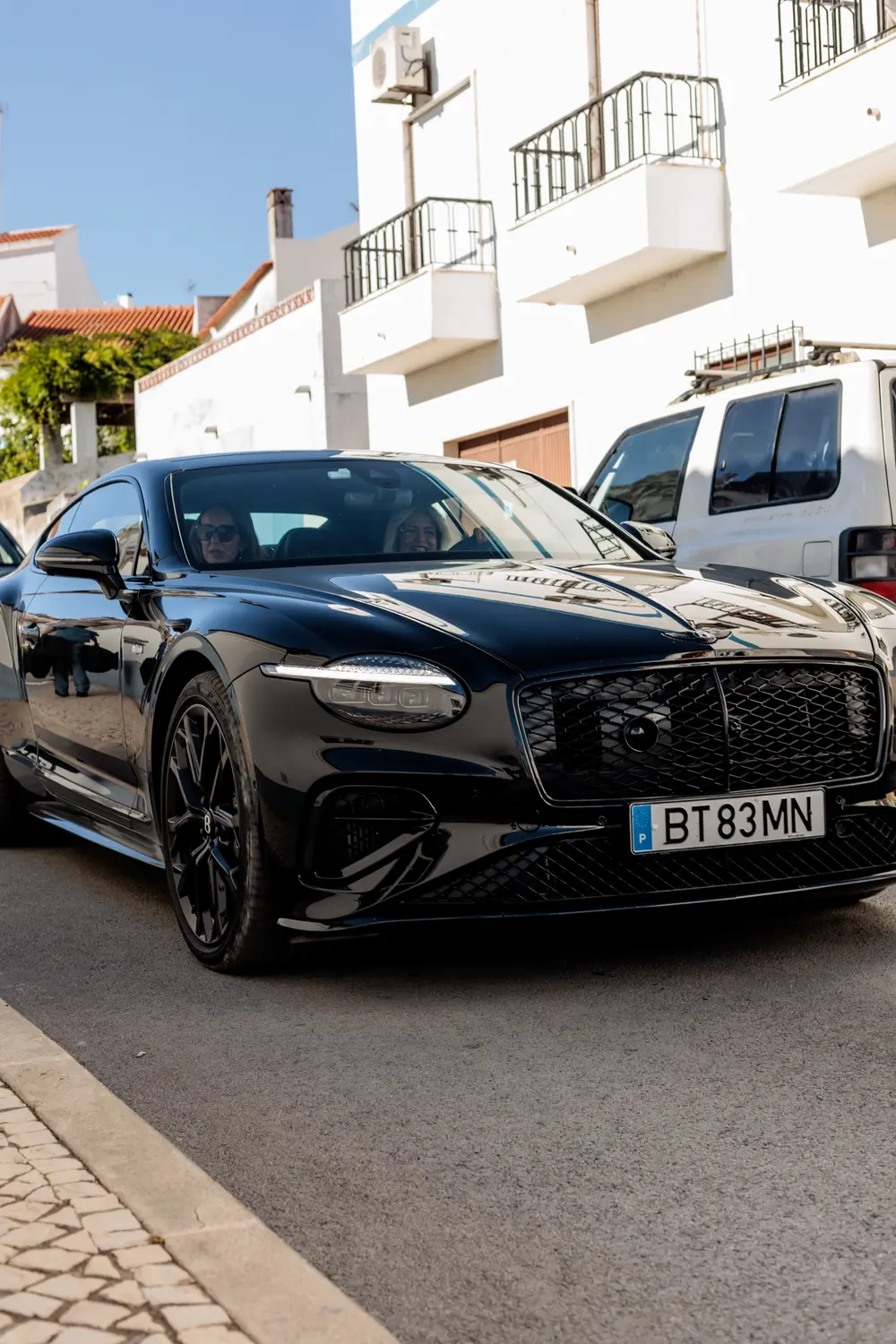 Bentley a circular entre as casas brancas da vila