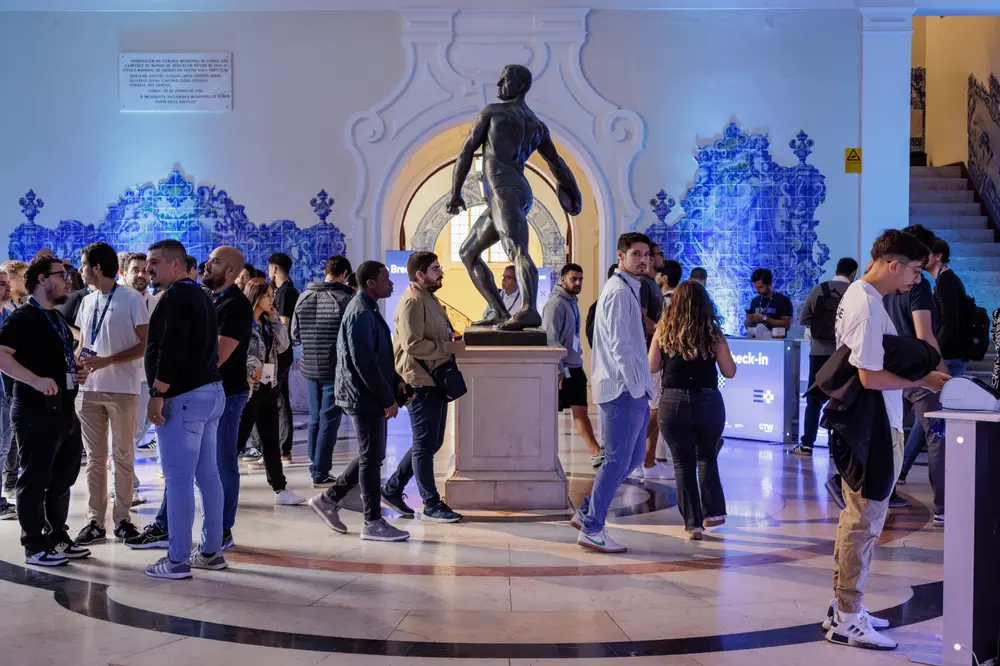 Participantes em conversa no átrio, à volta da estátua