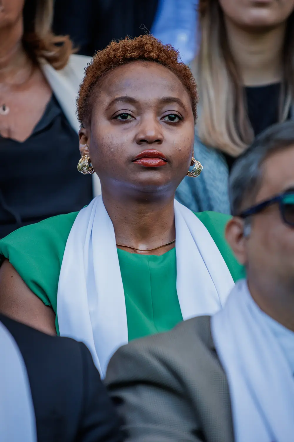 Retrato de uma graduada de verde, com o cachecol da academia