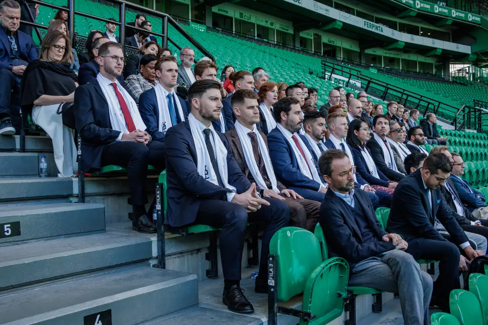 Fila de graduados sentados na bancada do estádio