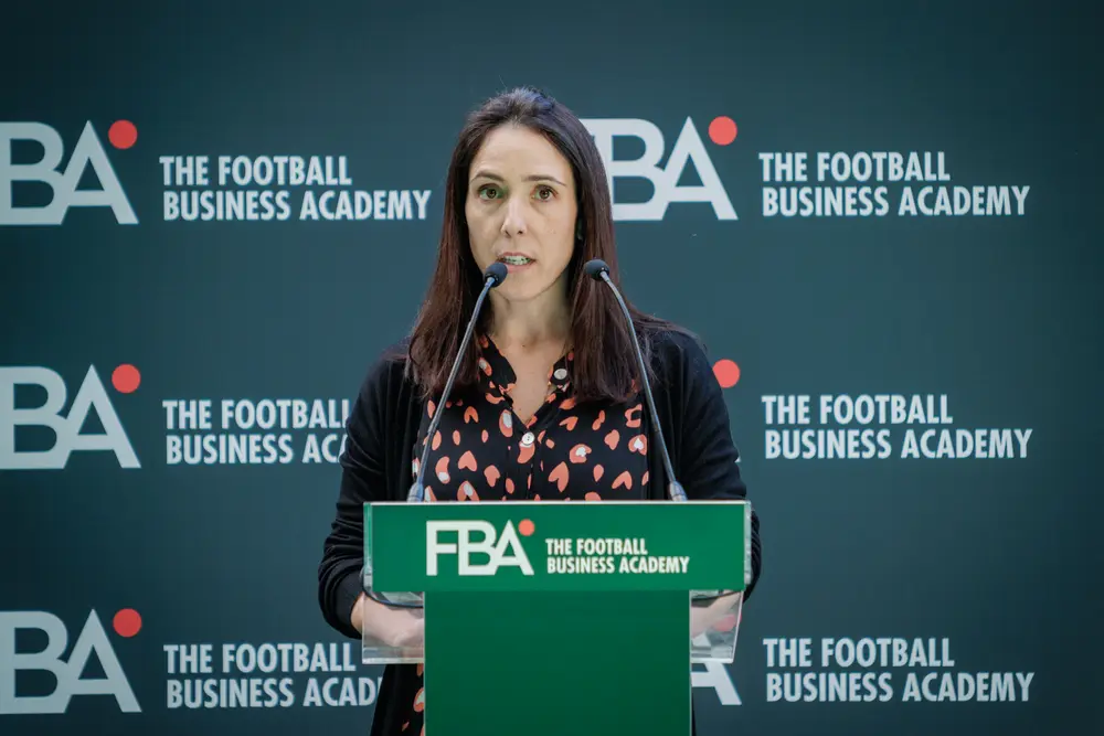 Oradora no púlpito, diante do painel da academia