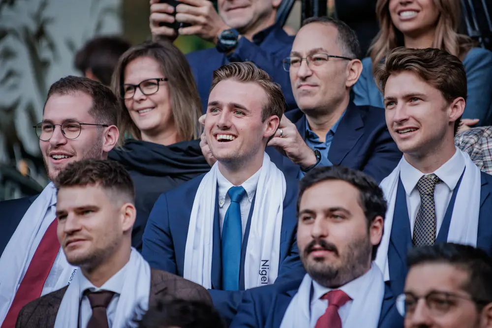 Grupo de graduados a sorrir durante a cerimónia
