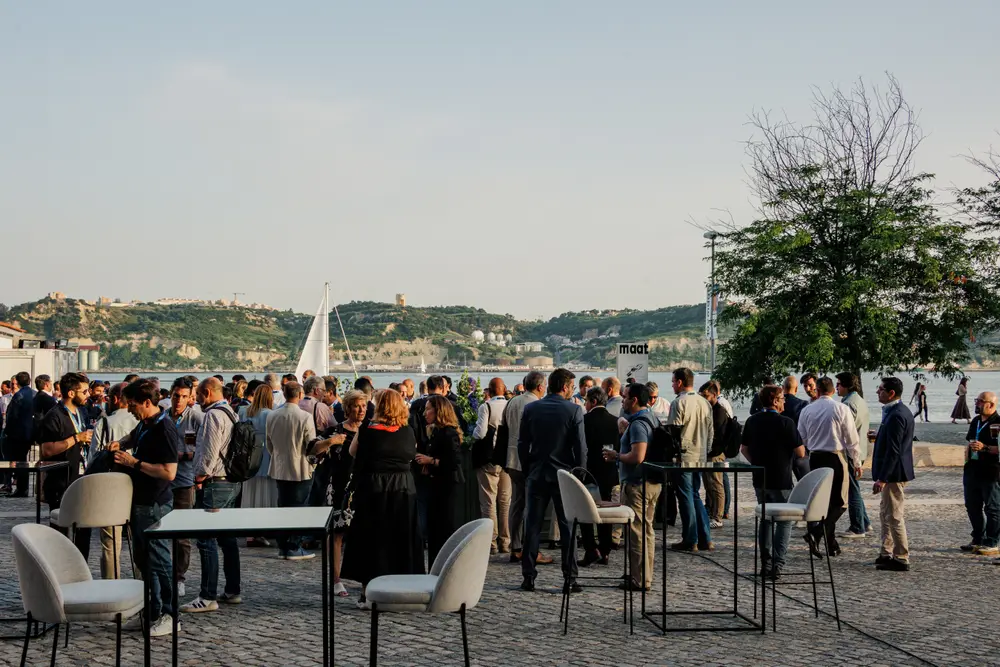 Plano geral do cocktail no terraço, com o rio ao fundo