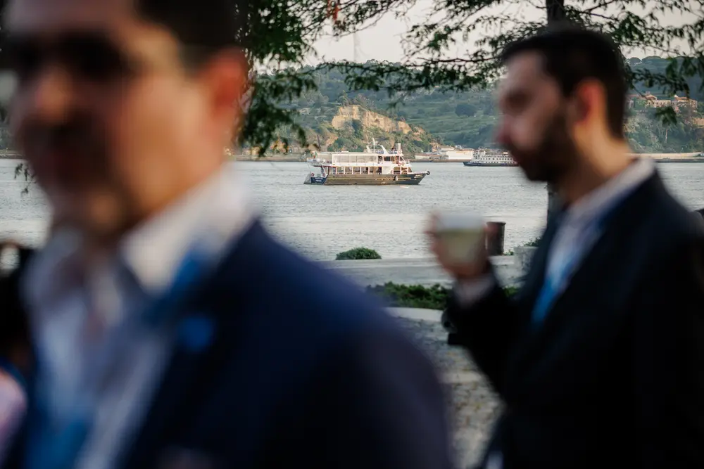 Dois convidados a conversar com o Tejo e um barco ao fundo