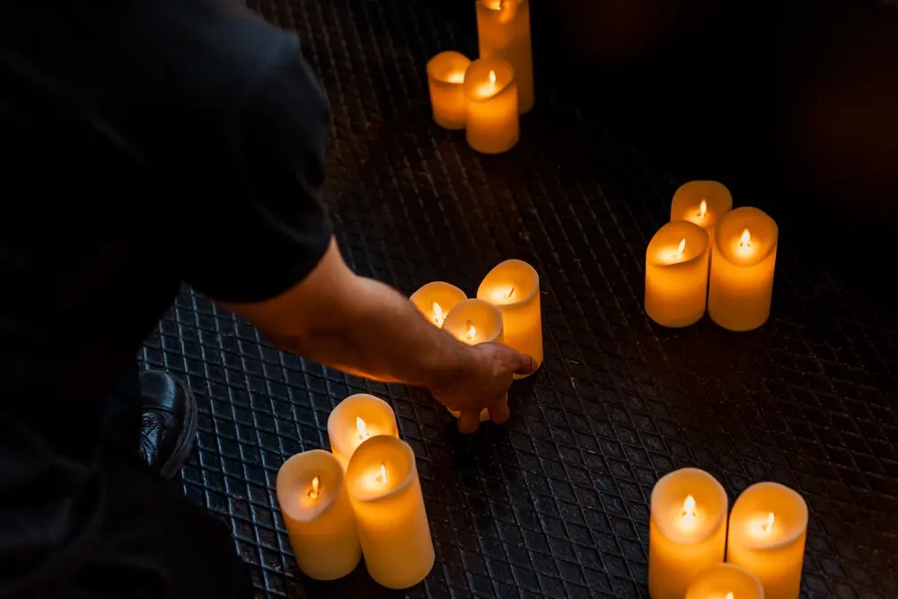 Mãos a colocar as velas da instalação, uma a uma