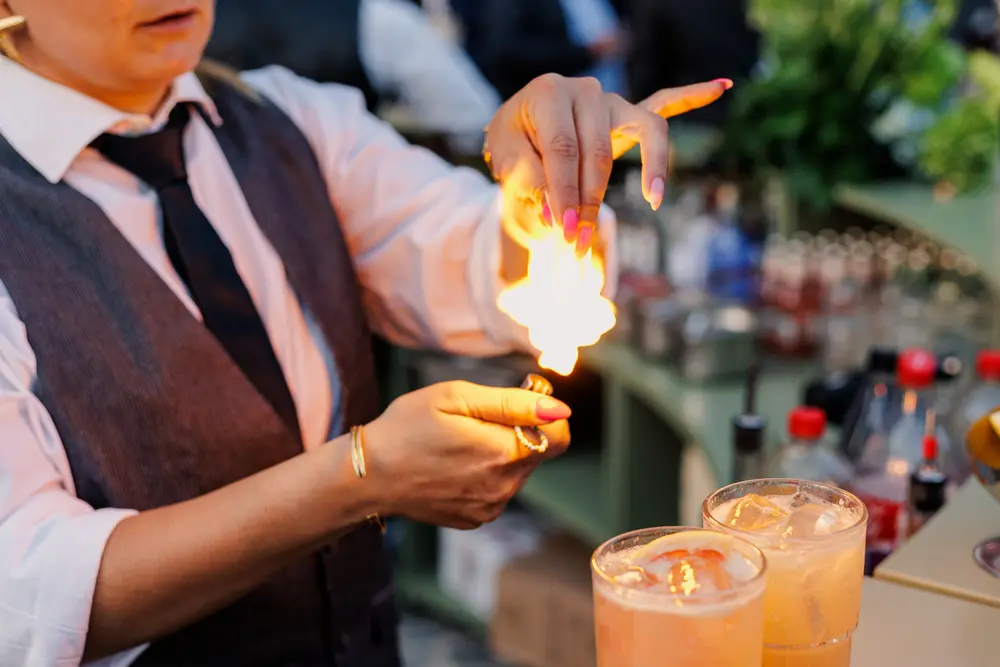 Barman a realizar um truque com cocktails no bar exterior