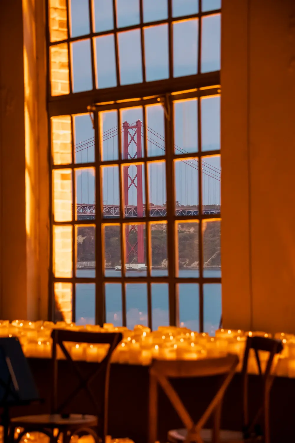 Sala iluminada por centenas de velas, com o rio visível pela janela