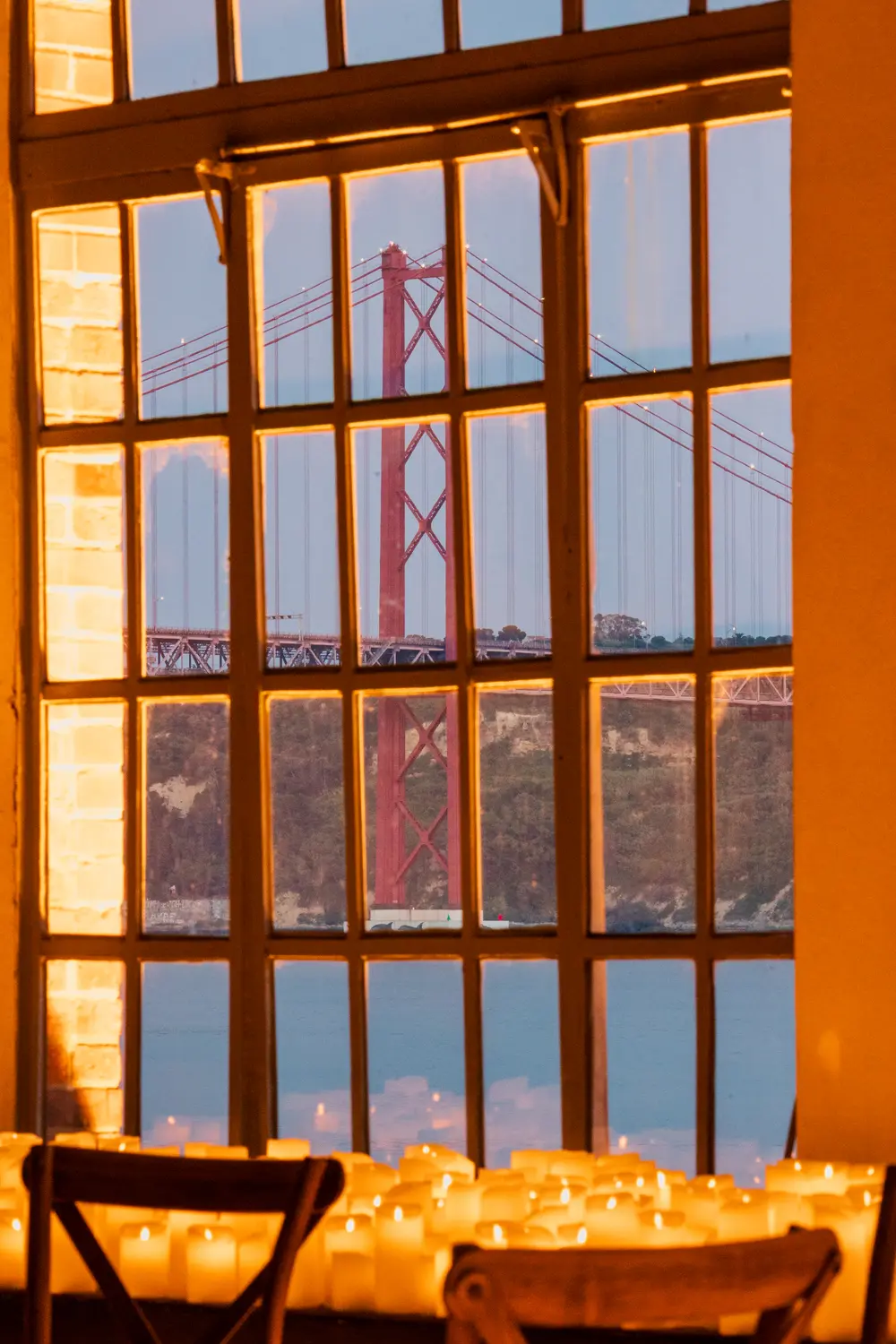 A ponte 25 de Abril vista pela janela da sala iluminada a velas