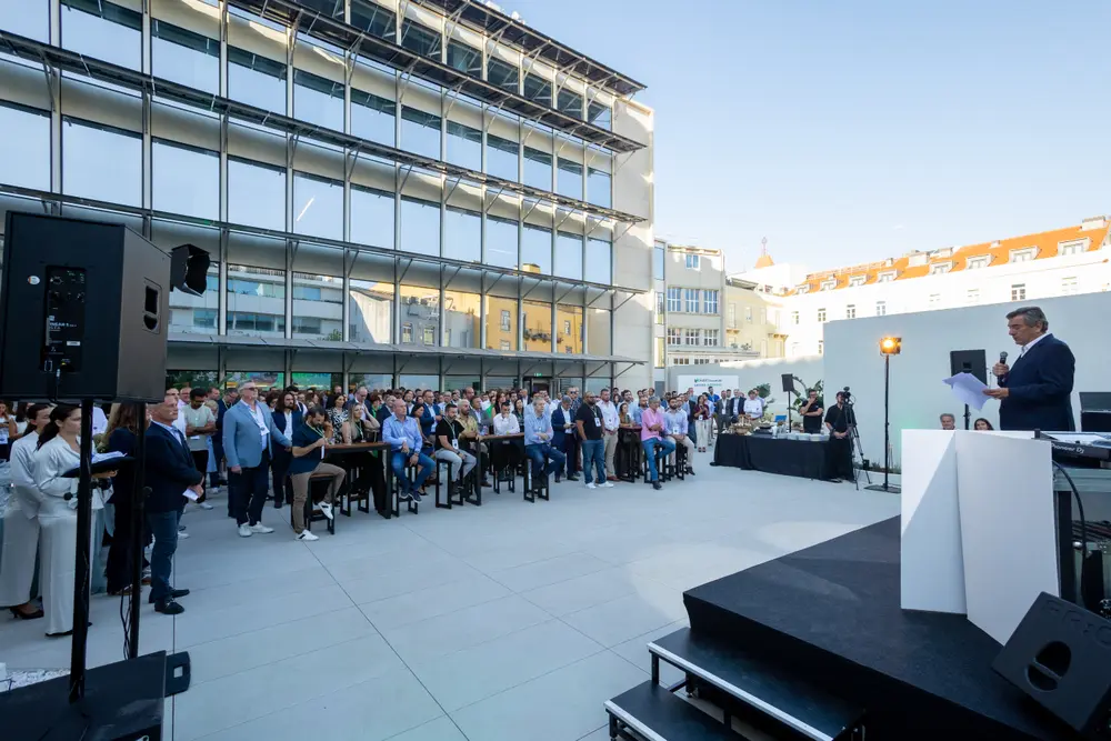 Plano geral do terraço durante os discursos, com a cidade ao fundo