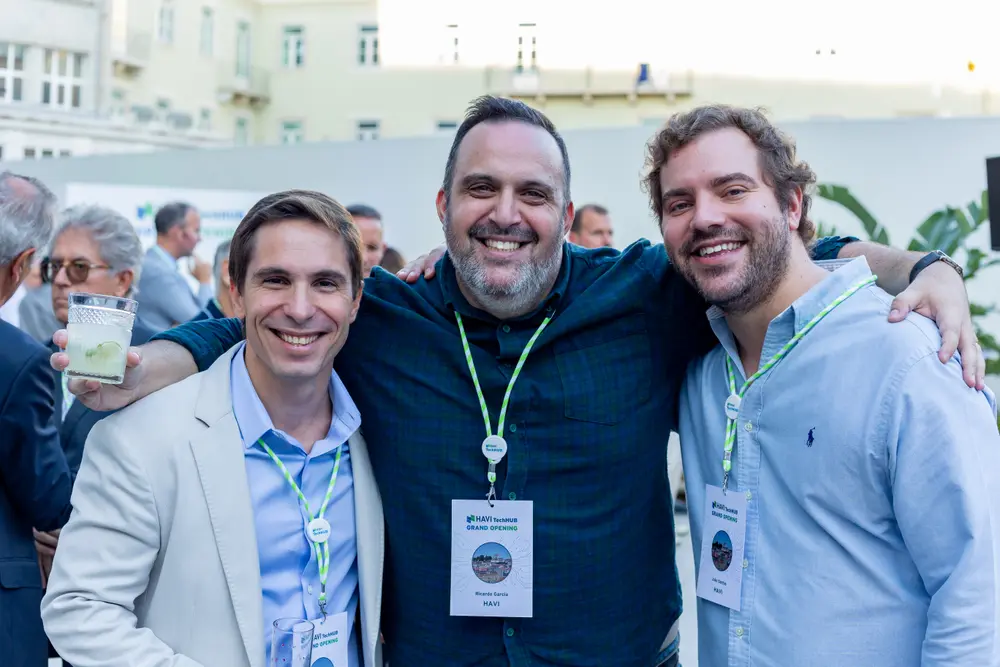 Três convidados a posar juntos, com a cidade ao fundo