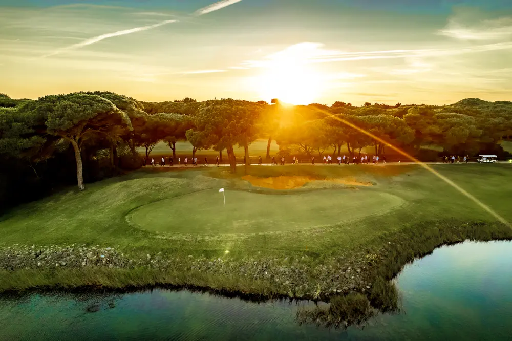 Sol a pôr-se sobre um green do campo de golfe