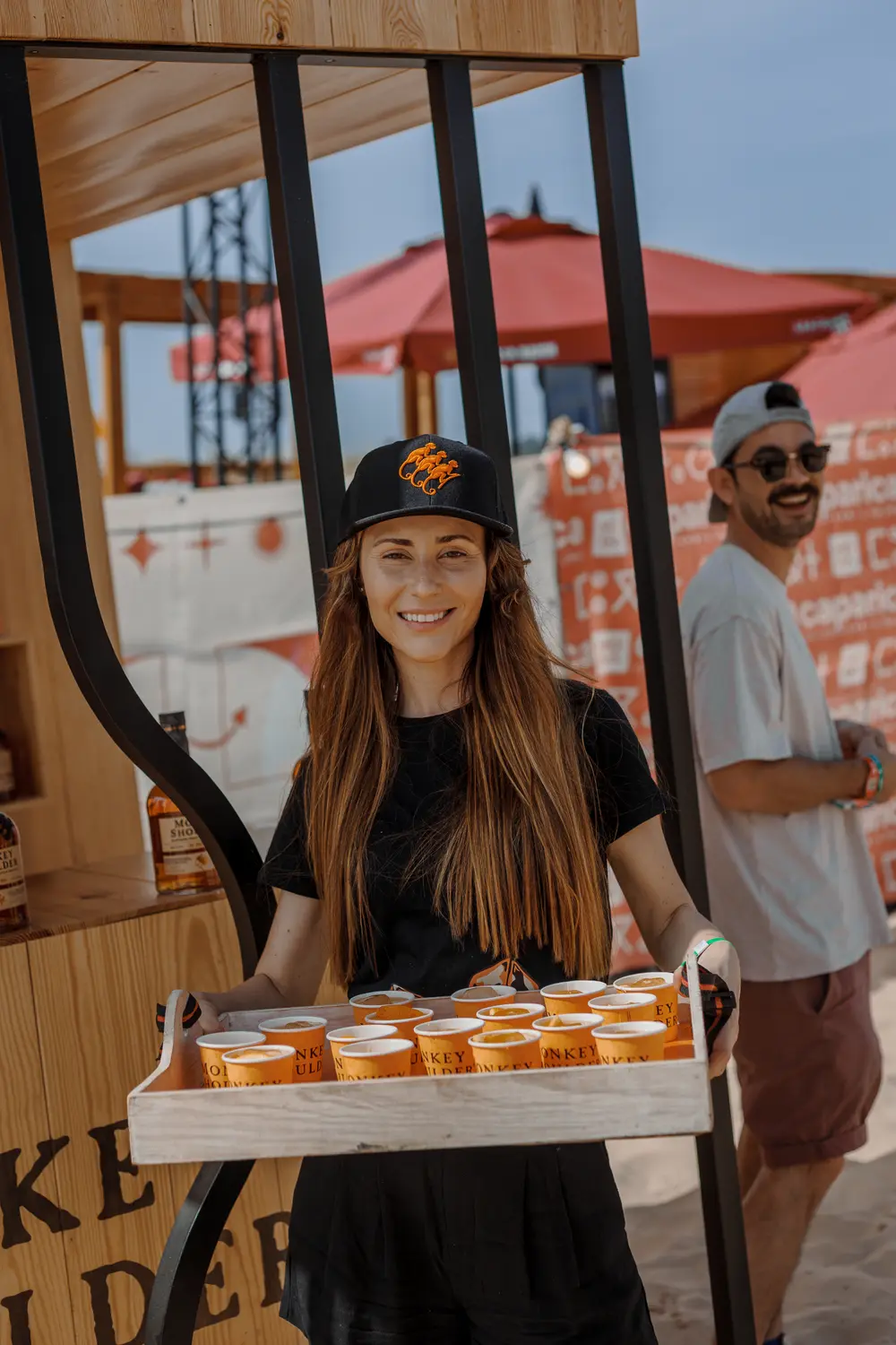 Empregada a transportar um tabuleiro de cocktails