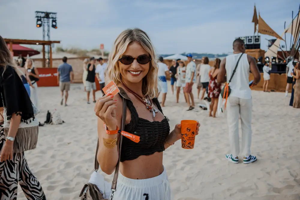 Festivaleira a levantar o copo de marca para a câmara