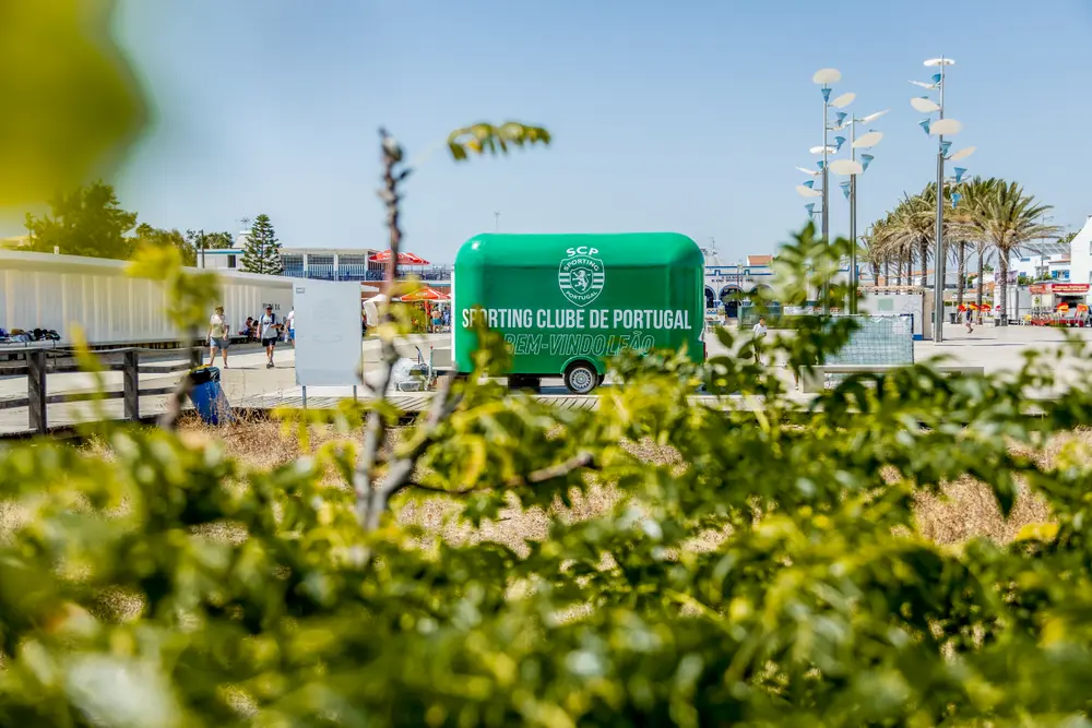 Carrinha do clube vista de longe, entre a vegetação