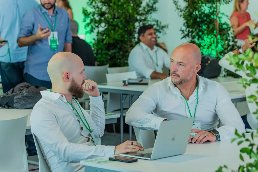 Dois participantes em conversa à mesa de trabalho