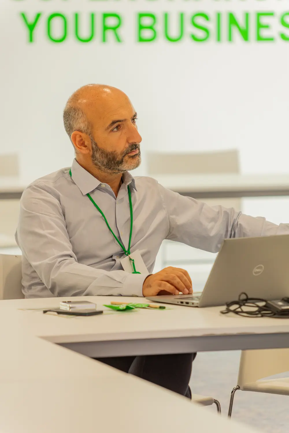 Participante a trabalhar, com a mensagem da marca projetada atrás