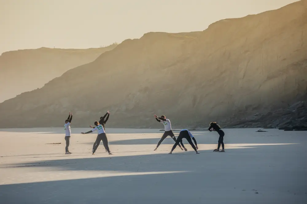 Aquecimento na areia antes da aula de surf