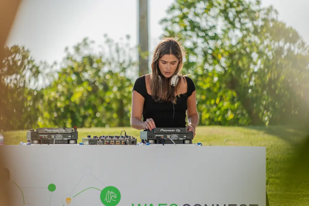 DJ a atuar junto à cabine de marca, ao ar livre
