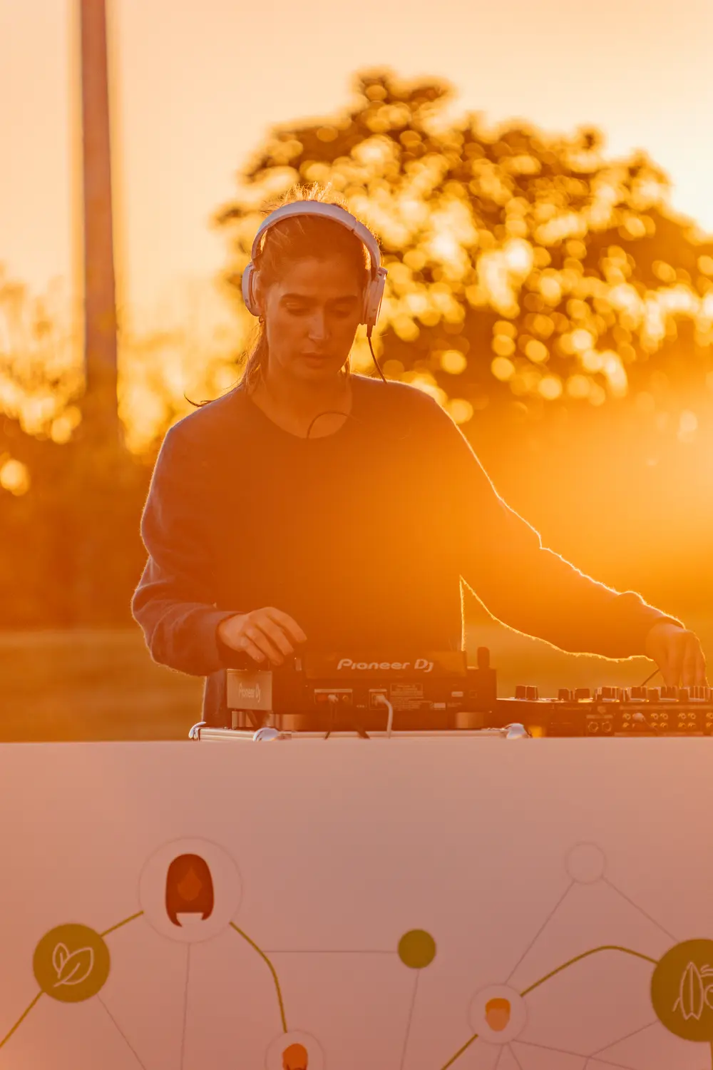 DJ a atuar ao pôr do sol, em contraluz