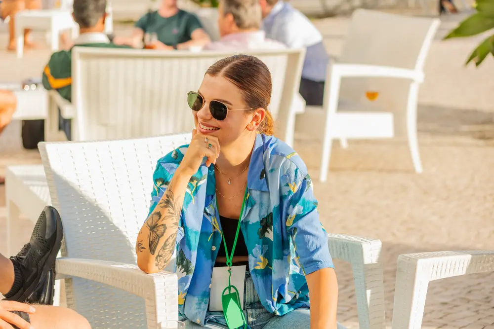 Participante a conversar no terraço, entre as mesas